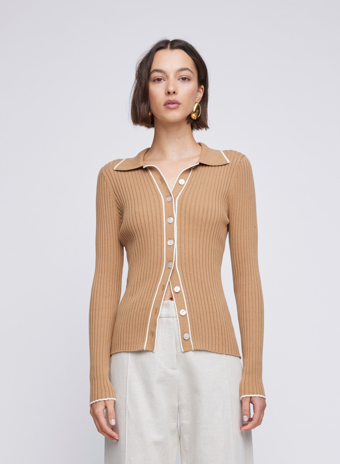 ANNA QUAN's signature style shines in our Cotton Rib Long Sleeve Polo Knit Top. With contrast trims and a button-up design, this versatile piece seamlessly blends comfort and sophistication for a refined everyday look.