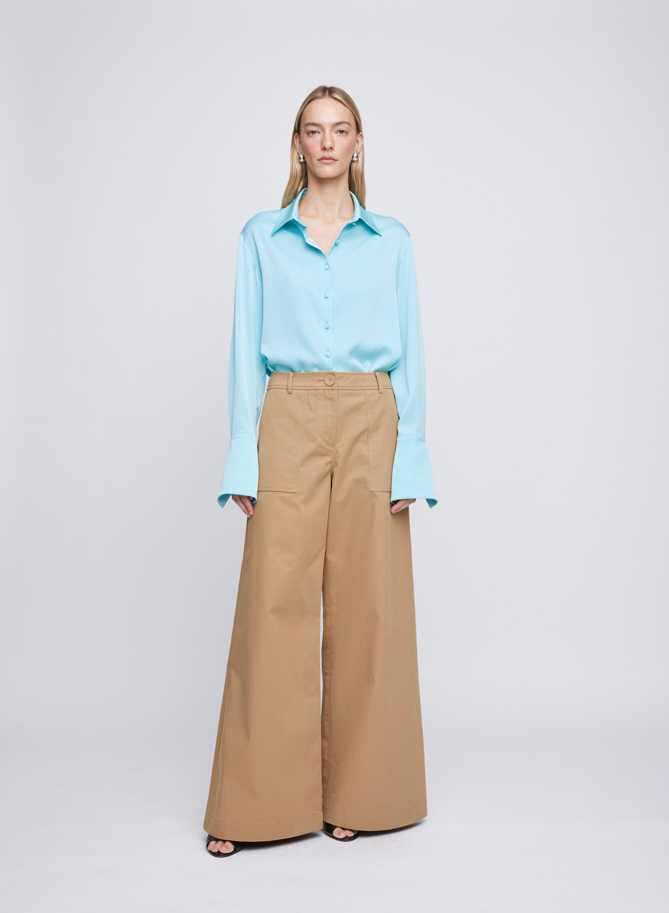 The ANNA QUAN Lana Shirt in Electric Teal is a collared shirt cut in a Japanese satin for a luxurious finish. Featuring extended cuffs and matching buttons to elevate the piece.