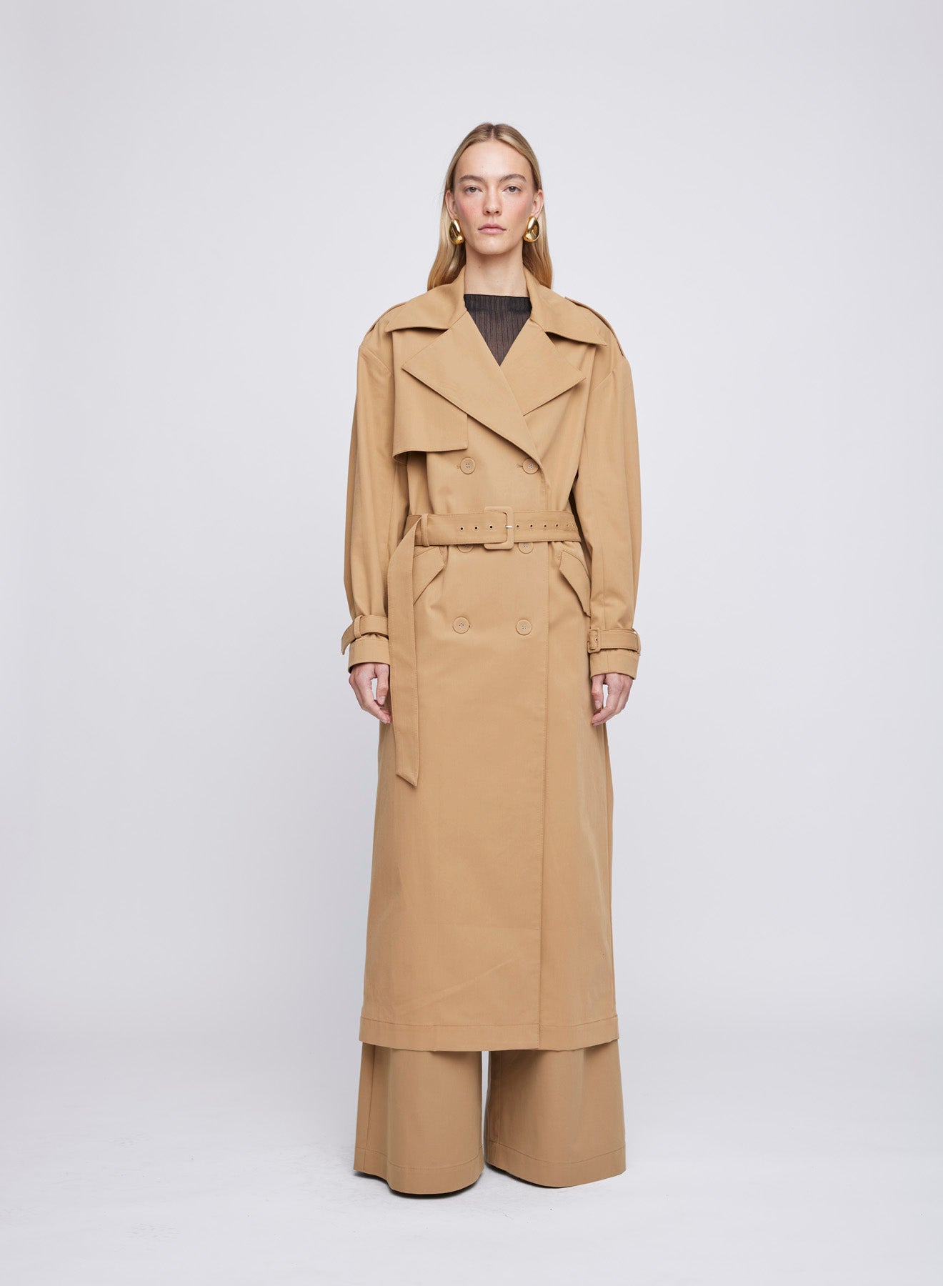 The ANNA QUAN Madden Coat in Tan is a water resistant trench with a double breasted silhouette and a removable belt.