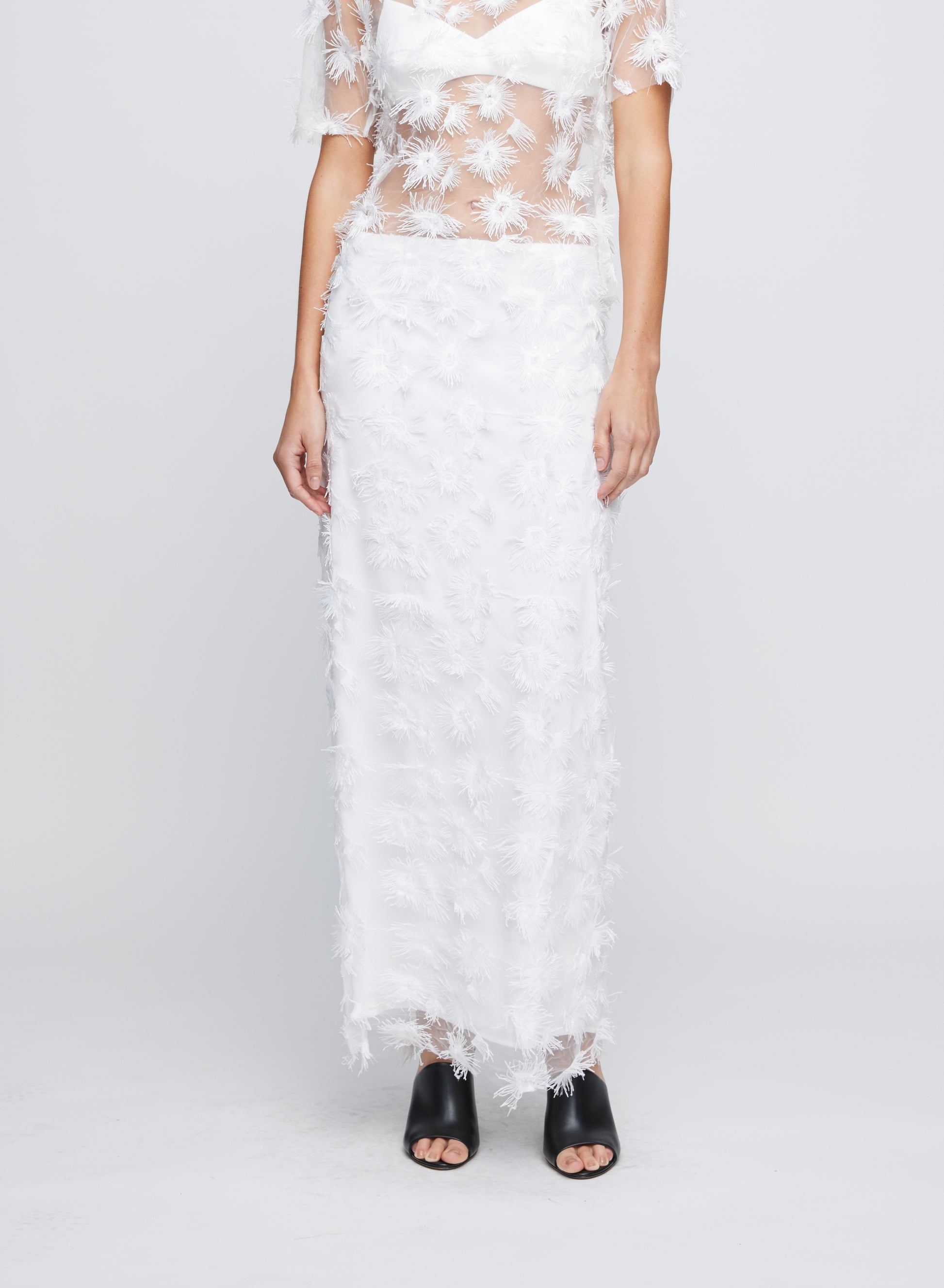 The Anna Quan Carmela Skirt in Dandelion is the perfect romantic occasion piece that sits mid to high on the waist and cut in a a sheer fabric with applique detailing.