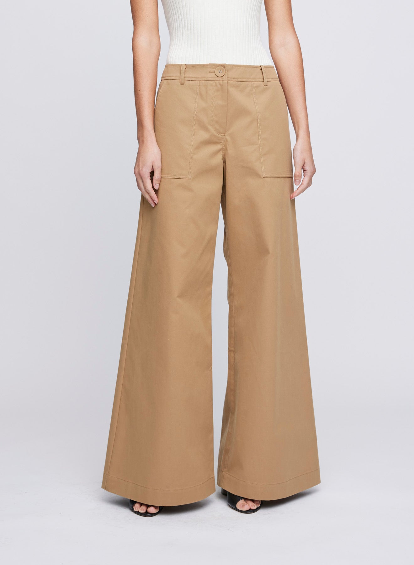 The ANNA QUAN Sloane Pants in Tan are crafted in a canvas linen material that sit mid-rise on the waist and have a wide leg fit.