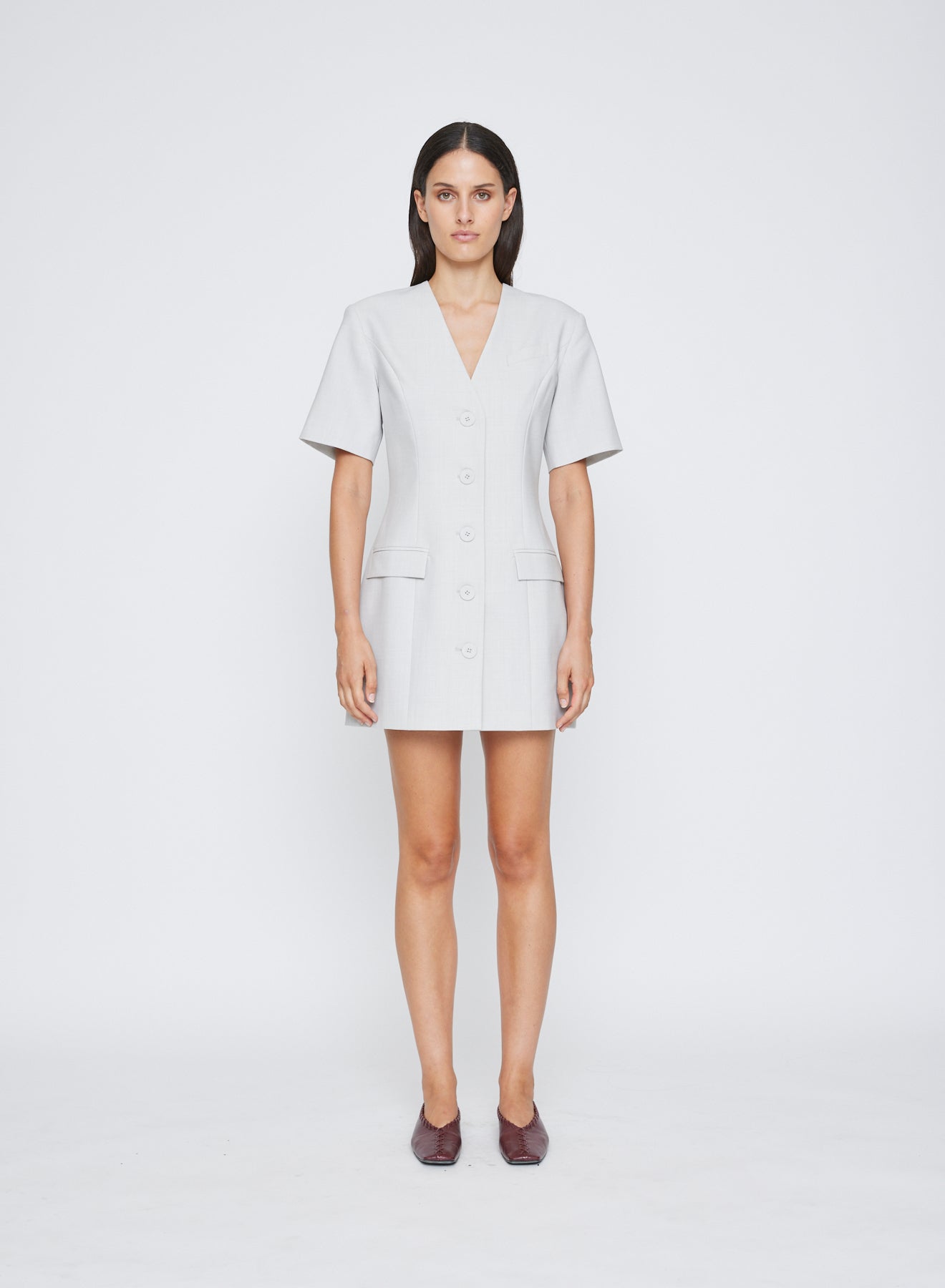 The ANNA QUAN Romy Dress features feminine seam work that shapes the waist line, a v cut neckline and flap pockets. Finishing touches include a button down front and A-line hem. Fully lined for ease of wear and crafted in heather wool suiting.